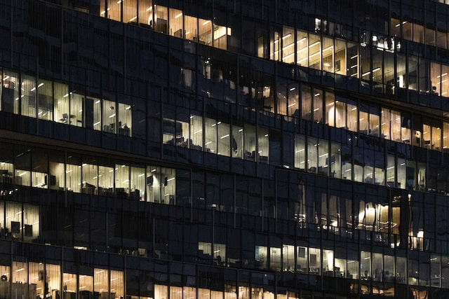 Ausschnitt eines Büro Hochhauses bei Nacht in dem noch viele Leute arbeiten